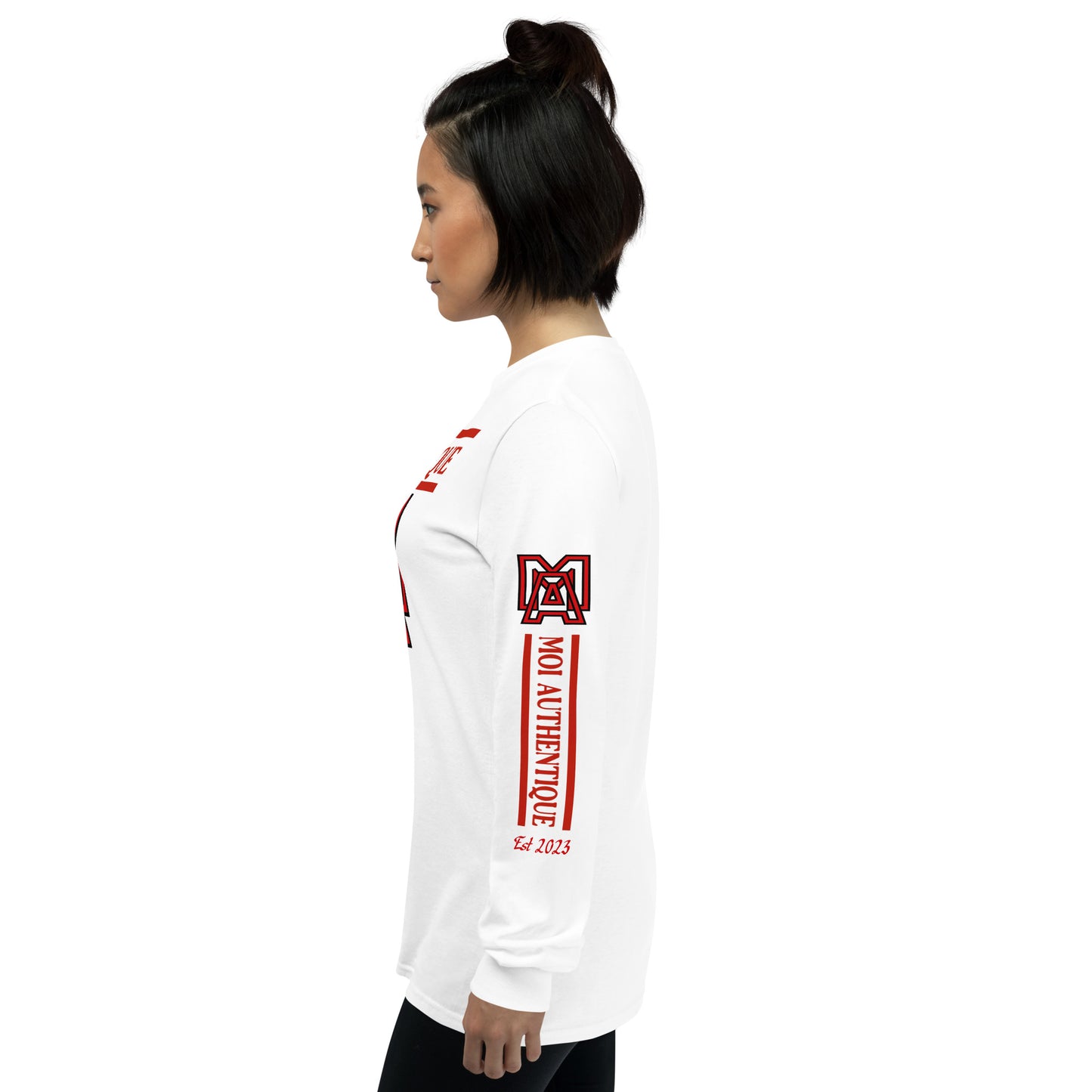 Side view of woman wearing a long-sleeved white shirt with text and logos on it, standing against a plain background.