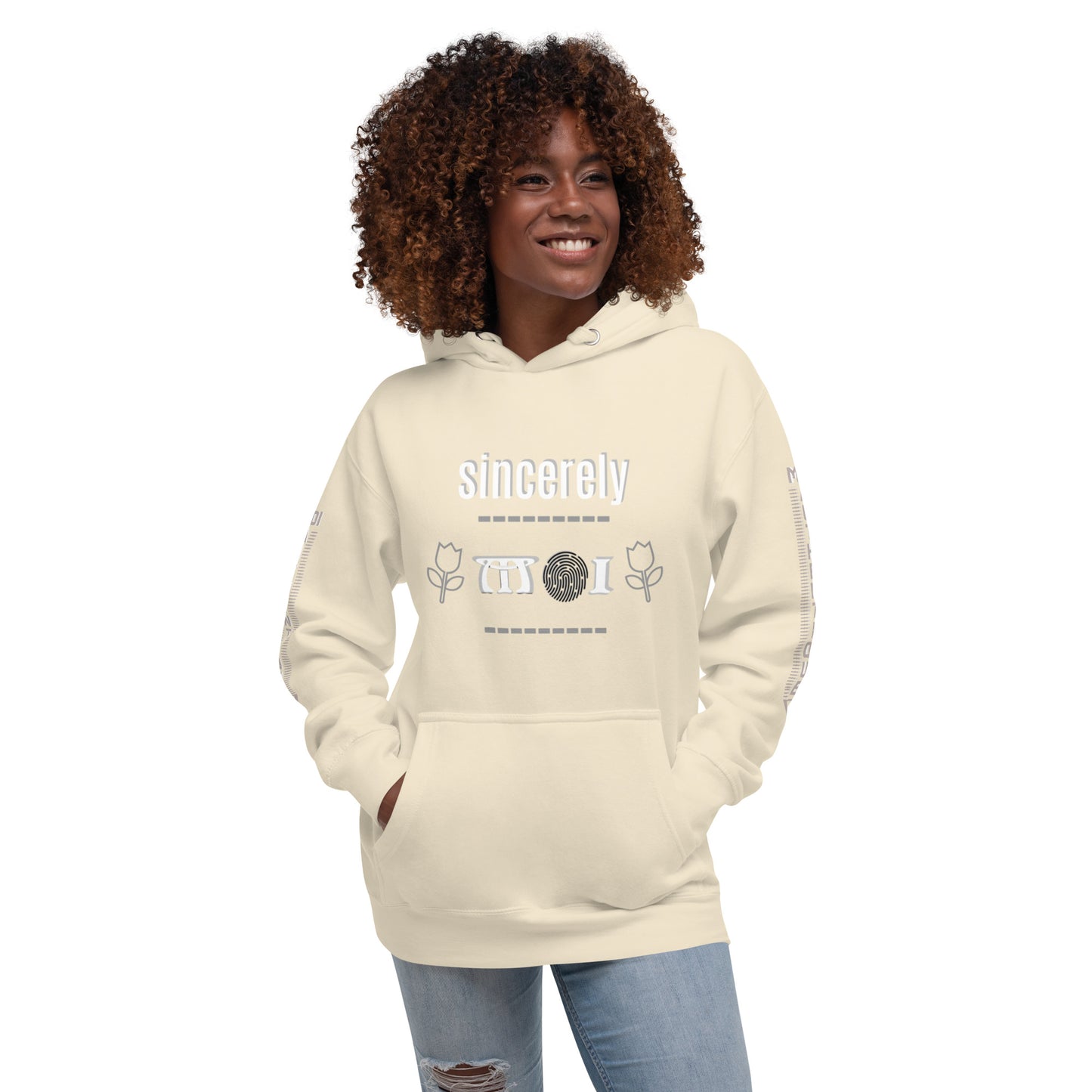 A woman wearing a beige unisex hoodie with a front pouch pocket and drawstrings, standing against a white background.