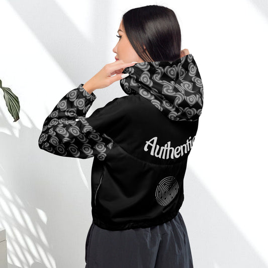 View of a woman wearing a black cropped windbreaker with a hood, featuring side-slit pockets and a breathable mesh lining.