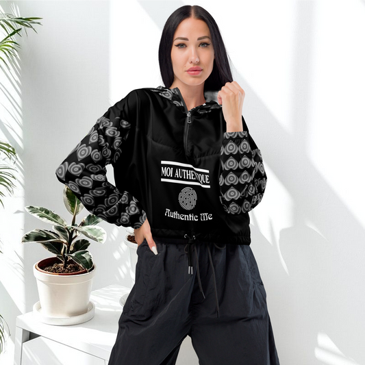A woman wearing a black cropped windbreaker with a hood, featuring side-slit pockets and a breathable mesh lining.