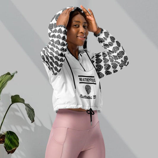 A woman wearing a cropped windbreaker with side-slit pockets, breathable mesh lining, and adjustable drawcords. The windbreaker is predominantly white with a geometric pattern.