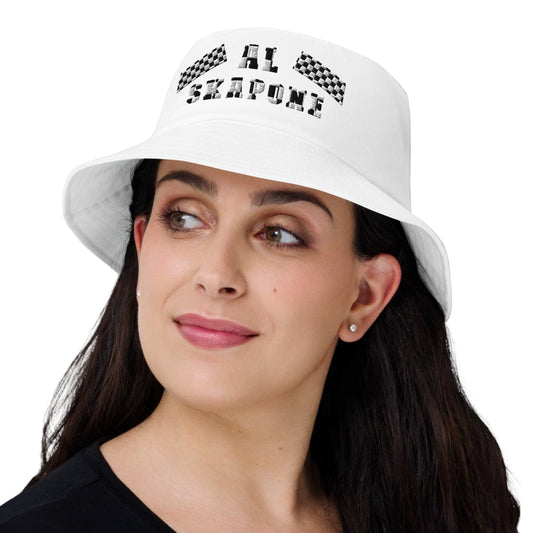 A woman wearing a white embroidered bucket hat with the text 'Al Skapone' on it.
