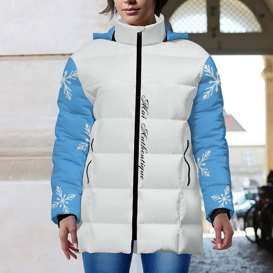 White puffer jacket with blue sleeves and snowflake patterns worn by a person.