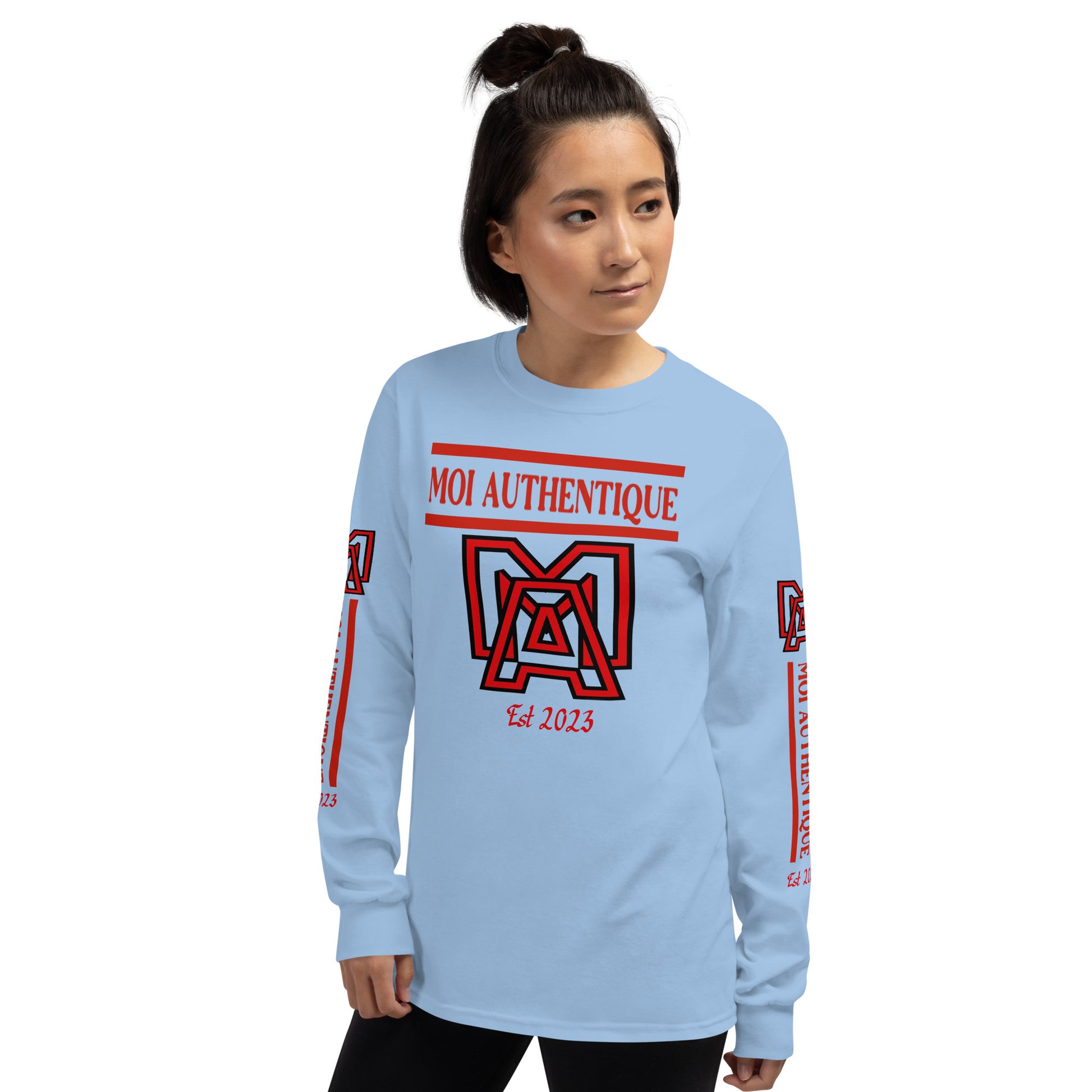 Side-on view of a woman wearing a long-sleeved blue shirt with red text and graphics, including the brand name 'Moi Authentique' across the chest