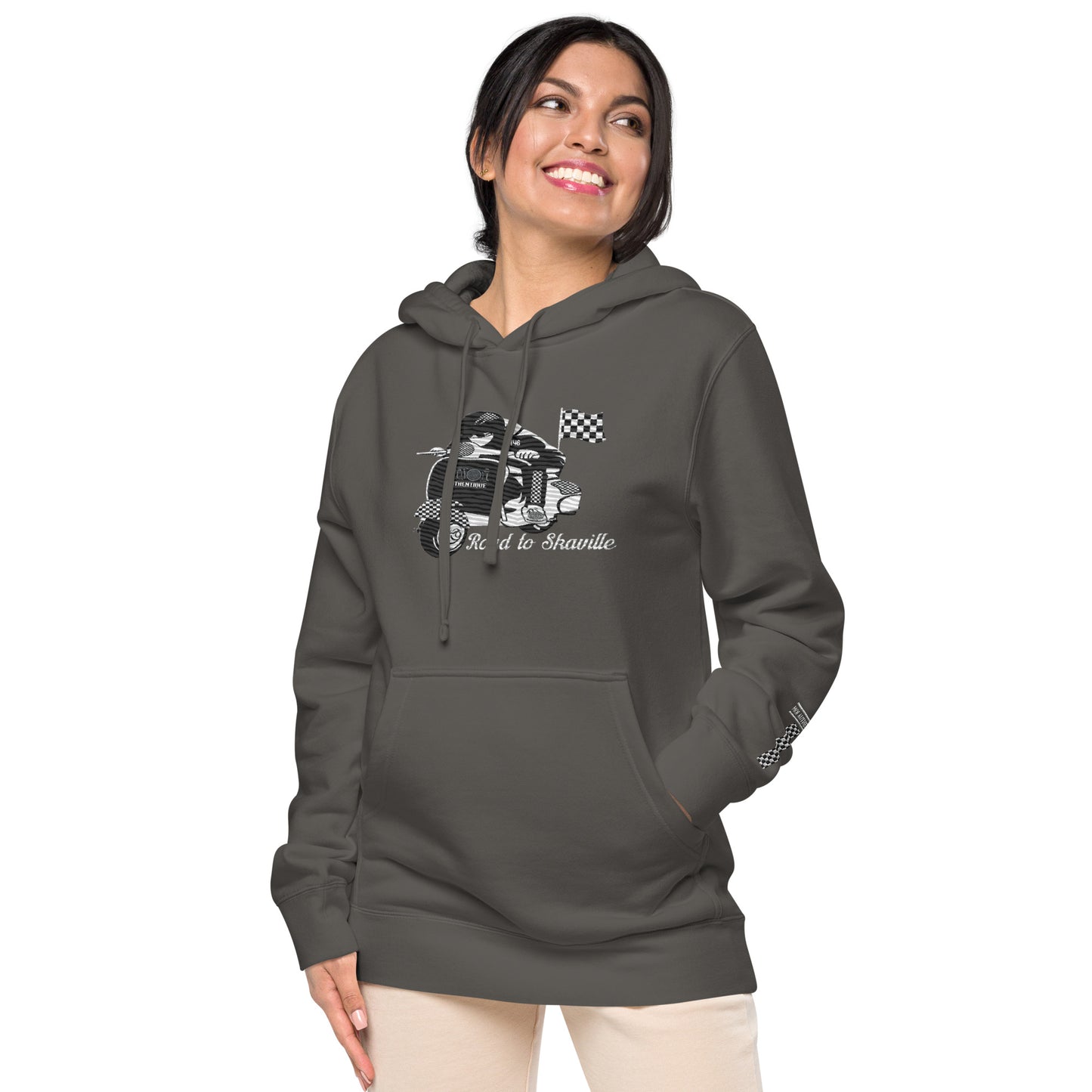 image showing a woman wearing a black pigment-dyed hoodie with front and sleeve embroidery featuring a vintage moped design and the text 'Road to Skaville'.